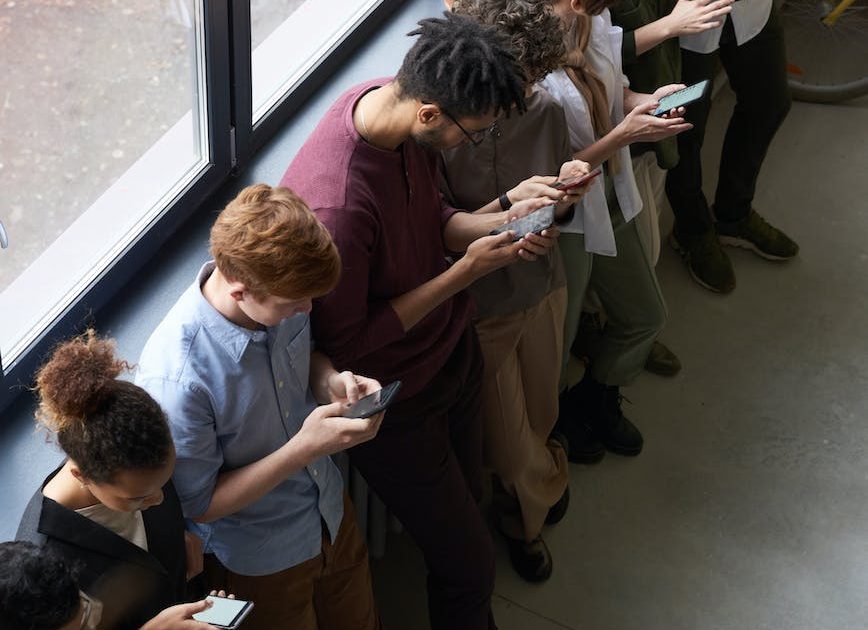 ihmisiä pitelemässä kännykkäänsä