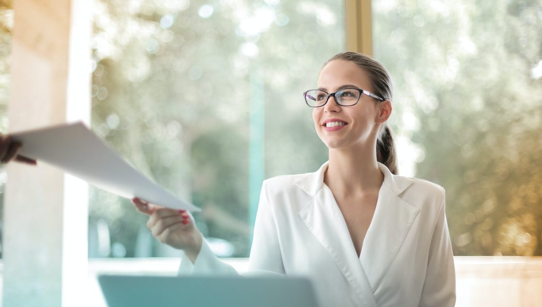 positive businesswoman doing paperwork in office